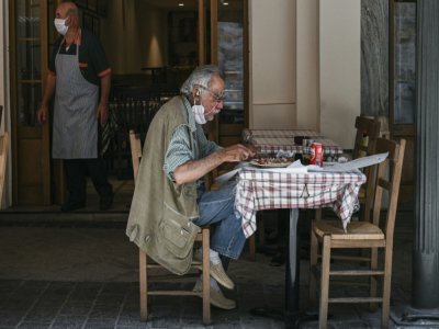 A la terrasse d'une taverne à Athènes, le 25 mazi 2020 - ARIS MESSINIS [AFP]