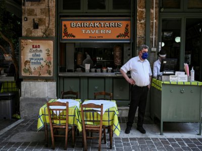 Dans l'attente des clients, à la terrasse d'une taverne à Athènes, le 25 mai 2020 - ARIS MESSINIS [AFP]