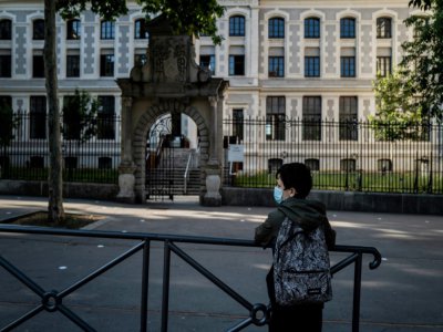 Un écolier porte un masque devant son école à Lyon, centre-est, le 18 mai 2020 - JEFF PACHOUD [AFP]