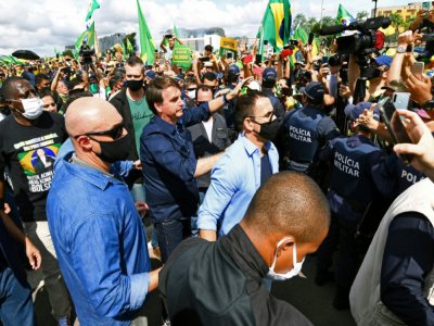 Le président du Brésil Jair Bolsonaro sans masque  accueille ses supporters, lors de son arrivée au palais présidentiel à Brasilia, le 24 mai 2020 - EVARISTO SA [AFP]