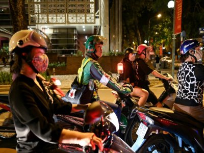 Pham Quoc Viet, chauffeur de moto-taxi le jour et secouriste la nuit, à Hanoï la nuit le 12 mai 2020 - Manan VATSYAYANA [AFP]