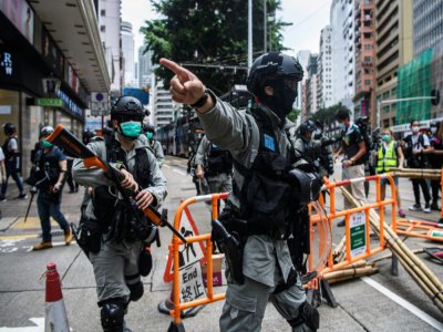 Les forces de police nettoient les rues après un rassemblement en faveur de la démocratie, à Hong Kong le 24 mai 2020 - ANTHONY WALLACE [AFP/Archives]