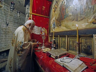 Un prêtre orthodoxe prépare la messe, dans l'église de la Nativité à Béthléhem, le 26 mai 2020 - Musa Al SHAER [AFP]