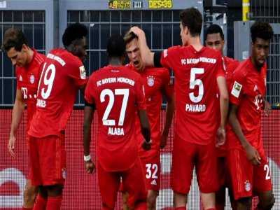 Le milieu du Bayern Munich, Joshua Kimmich (c), félicité par ses coéquipiers après son  but à Dortmund, en Bundesliga, le 26 mai 2020 - Federico GAMBARINI [POOL/AFP]