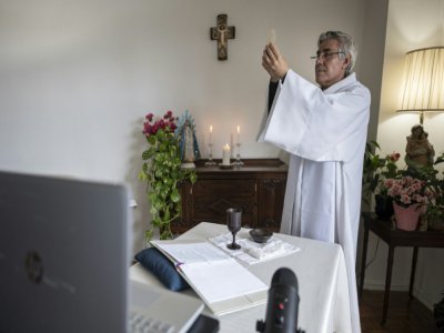 Le père Fabian Arias lors d'une bénédiction pendant une messe dite depuis sa résidence du Bronx, le 24 mai 2020, et retransmise en live sur internet pour ses fidèles - Johannes EISELE [AFP]