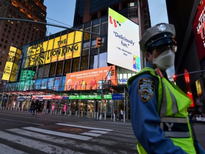 Un policier porte un masque de protection à Times Square, le 27 mai 2020 à New York - Angela Weiss [AFP]