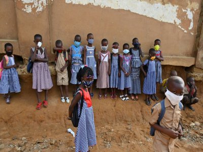 Des enfants portent un masque de protection devant leur école, le 25 mai 2020 à Abidjan, en Côte d'Ivoire - Issouf SANOGO [AFP/Archives]