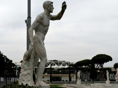 Une statue à l'extérieur du stade olympique (en arrière plan) de Rome le 17 mars 2020 - Filippo MONTEFORTE [AFP/Archives]
