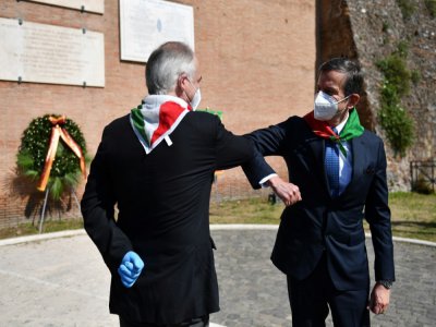 Deux membres de la fédération italienne  des partisans se saluent lors d'une cérémonie de commémoration du jour de la Libération, qui marque la chute de l'Allemagne nazie, à Rome le 25 avril 2020 - Tiziana FABI [AFP/Archives]