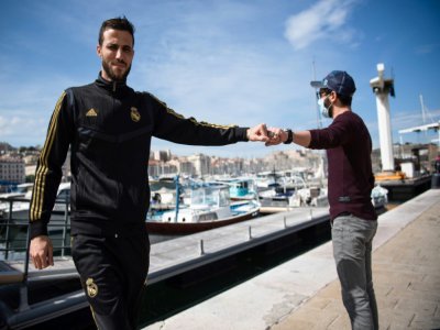 Deux hommes se saluent sur le Vieux port de Marseille, le 17 mai 2020 - CLEMENT MAHOUDEAU [AFP]