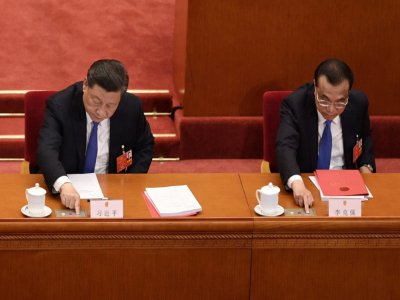 Le président chinois Xi Jinping (G) et le Premier ministre Li Keqiang votent sur une mesure prévoyant une loi sur la sécurité à Hong Kong, lors de la séance de clôture d'une session du Parlement à Pékin, le 28 mai 2020 - NICOLAS ASFOURI [AFP]