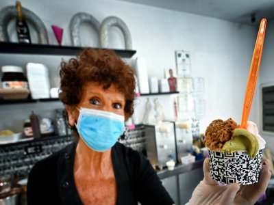 Maddalena sert une glace à un client chez Brivido dans le quartier de Testaccio à Rome alors que le pays a assoupli son confinement contre le coronavirus, le 26 mai 2020 - Alberto PIZZOLI [AFP]