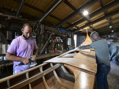 Des charpentiers travaillent sur une gondole au "squero" de Roberto Dei Rossi, le 27 mai 2020 à Venise - MIGUEL MEDINA [AFP]