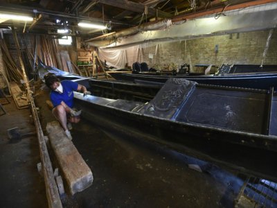 Elena Tramontin travaille sur une gondole dans le "squero" Tramontin, le 27 mai 2020 à Venise - MIGUEL MEDINA [AFP]