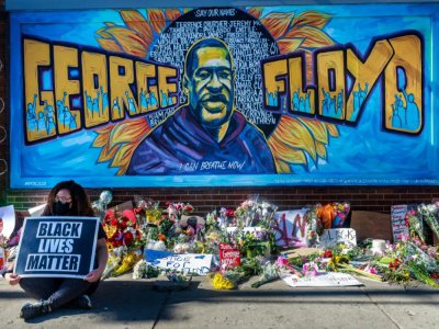 Fleurs et pancartes devant un mémorial de fortune près de l'endroit où George Floyd a été tué au cours de son interpellation, à Minneapolis - Kerem Yucel [AFP]