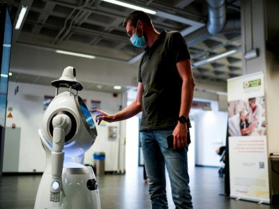 Un employé de la compagnie ZoraBots teste un robot appelé CRUZR le 29 mai 2020 à l'hôpital d'Anvers - Kenzo TRIBOUILLARD [AFP]