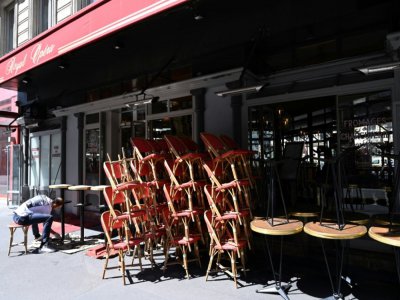 Un employé installe des tables et des chaises avant la réouverture des terrasses des cafés, bars et restaurants, le 30 mai 2020 à Paris - BERTRAND GUAY [AFP]