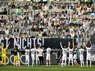 Les joueurs de Mönchengladbach saluent les milliers d'effigies en carton de leurs supporters dans les tribunes à l'issue du match contre l'Union Berlin, à Mönchengladbach, le 31 mai 2020 - Martin Meissner [POOL/AFP]