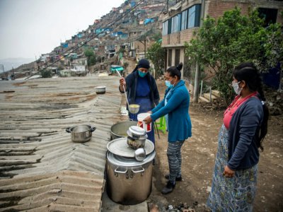 Une religieuse sert de la nourriture dans une soupe populaire d'un quartier pauvre de Lima (Pérou) le 28 mai 2020, où les habitants souffrent de la crise économique entraînée par la pandémie de nouveau coronavirus - Ernesto BENAVIDES [AFP]