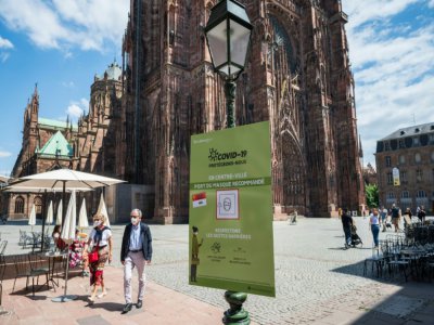 Une affiche accrochée à un lampadaire rappelle les gestes barrières et invite les personnes à porter un masque de protection, le 30 mai 2020 à Strasbourg - PATRICK HERTZOG [AFP]