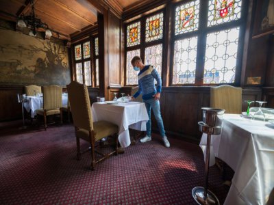Un employé du restaurant la Maison Kammerzell prépare une table, le 30 mai 2020 à Strasbourg - PATRICK HERTZOG [AFP]