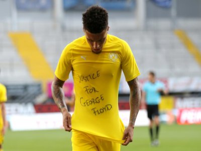 Le milieu de terrain de Dortmund, Jadon Sancho, dévoile un t-shirt en hommage à George Floyd lors de la célébration de son but face à Paderborn, le 31 mai 2020 - Lars Baron [POOL/AFP/Archives]