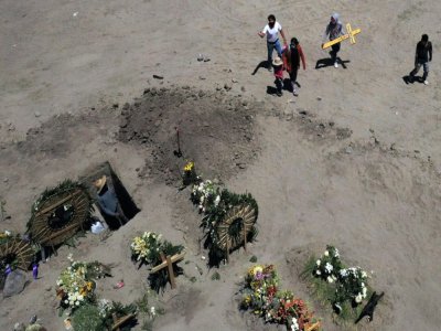 Les proches d'une victime du Covid-19 portent une croix, dans un cimetière de Valle de Chalco (Mexique), le 4 juin 2020 - ALFREDO ESTRELLA [AFP]