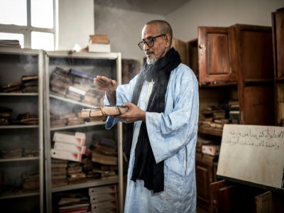 Le directeur du lycée Moumhamedou Ahmadou veille sur les vieux manuscrit, le 27 janvier 2020 à Tichitt, en Mauritanie - JOHN WESSELS [AFP]