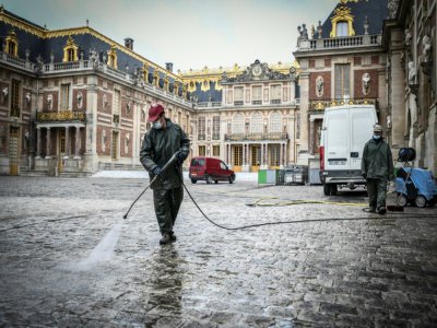 Des employés nettoient la cour d'honneur du château de Versailles le 5 juin 2020 - STEPHANE DE SAKUTIN [AFP]