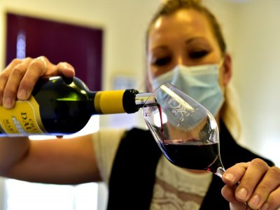 Une hôtesse verse du vin qui va être gouté par des professionnels à la maison du vin à Margaux, le 4 juin 2020 - GEORGES GOBET [AFP]