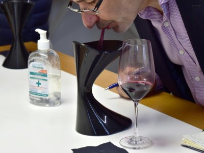 Un courtier utilise le crachoir après avoir gouté un vin lors d'une dégustation dans le laboratoire de l'œnologue Eric Boissenot à Lamarque près de Bordeaux, le 4 juin 2020 - GEORGES GOBET [AFP]