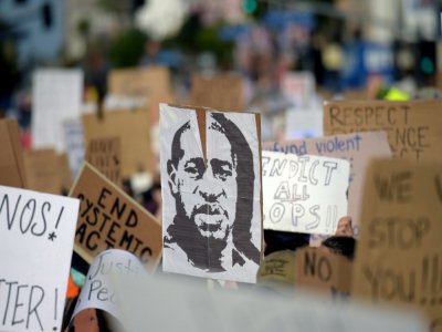 Des manifestants brandissent un portrait de George Floyd lors d'un rassemblement pour dénoncer le racisme et les violences policières, à Hollywood, le 7 juin 2020 - Agustin PAULLIER [AFP]