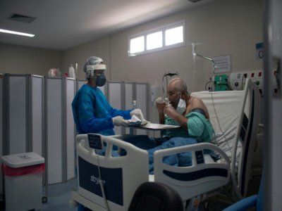 Un infirmière apporte un plateau à un malade du Covid dans un hôpital de Marica City, dans l'état de Rioo au Brésil, le 5 juin 2020 - Mauro Pimentel [AFP]