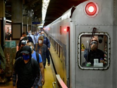 Des voyageurs sortent d'une rame de métro à la station de Grand Central, à Manhattan, le 8 juin 2020, première jour du début de déconfinement à New York - Angela Weiss [AFP]