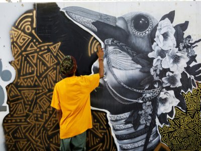 Un artiste termine son oeuvre sur "Graffiti Alley", le 11 juin 2020 à Toronto, au Canada - Cole BURSTON [AFP]