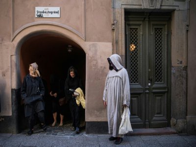 Le guide Mike Anderson, en costume, promène les visiteurs dans une "marche contre la peste", le 30 mai 2020 à Stockholm - Jonathan NACKSTRAND [AFP]