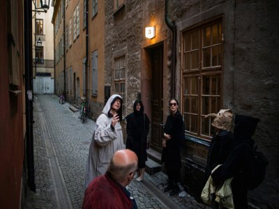 Le guide Mike Anderson, en costume, promène les visiteurs dans une "marche contre la peste", le 30 mai 2020 à Stockholm, racontant les grandes épidémies du passé - Jonathan NACKSTRAND [AFP]