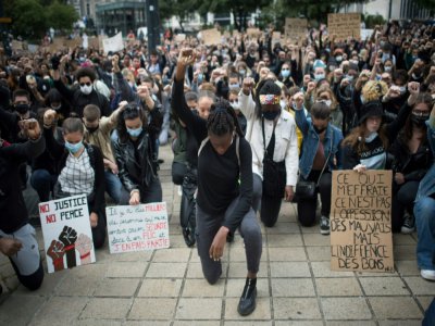 Des manifestants, genou à terre, lève le poing, lors d'un rassemblement contre le racisme et les violences policières, le  juin 2020 à Nantes - Loic VENANCE [AFP/Archives]
