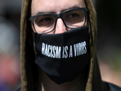 Un manifestant portant un masque clamant "Le racisme est un virus" à Londres, le 13 juin 2020 - DANIEL LEAL-OLIVAS [AFP]