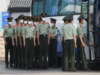 Des policiers chinois s'apprêtent à boucler les accès au marché Xinfadi de Pékin, le 13 juin 2020 - GREG BAKER [AFP]