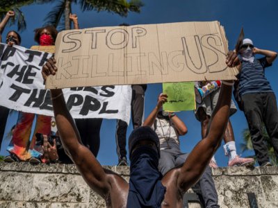 Un manifestant tient une pancarte "Arrêtez de nous tuer", le 31 mai 2020 à Miami, en Floride - Ricardo ARDUENGO [AFP/Archives]