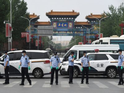 Des policiers chinois bloquent le 13 juin 2020 l'entrée au marché Xinfadi à Pékin, fermé après la découverte de cas de coronavirus - GREG BAKER [AFP]