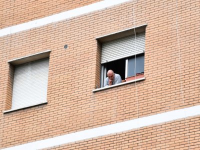 Un habitant de l'immeuble où un nouveau foyer de Covid-19 a été détecté, à la fenêtre de son appartement, le 13 juin 2020 à Rome - Tiziana FABI [AFP]
