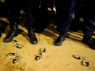 Des policiers français ont déposé des menottes à terre, lors d'une manifestation sur la place du Trocadéro à Paris le 14 juin 2020 - Thomas SAMSON [AFP]