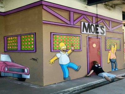 Blesea devant sa fresque du bar de Moe, à Caen. - Blesea