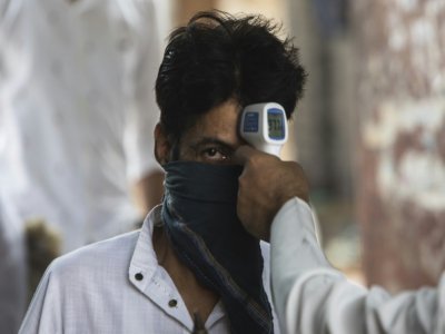 Un Indien musulman doit se faire prendre sa température avant de pouvoir aller prier à la mosquée Fatehpuri Masjid à New Delhi le 12 juin 2020 - XAVIER GALIANA [AFP]