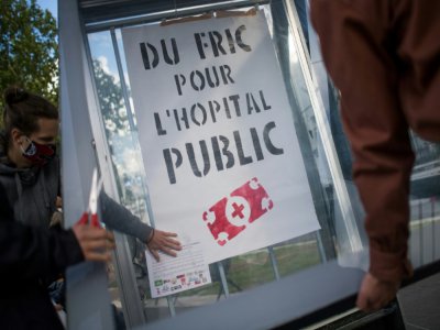 Des militants affichent un poster réclamant "du fric pour l'hôpital public"le 15 juin 2020 à Nantes - Loic VENANCE [AFP]