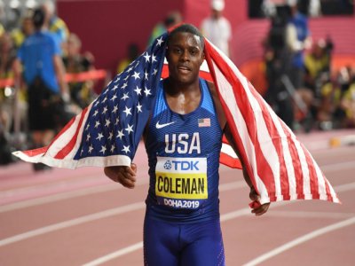 Le sprinteur américain Christian Coleman s'enroule dans le drapeau national après avoir gagné la finale du 100 m aux Mondiaux d'athlétisme, le 28 septembre 2019 à Doha - Kirill KUDRYAVTSEV [AFP/Archives]