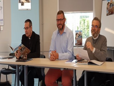 Olivier Malcurat, scénariste de la BD, entouré de l'Évêque Mgr Jacques Halbert en pleine lecture de la BD, et du père Thierry Esnault-Morel, recteur du sanctuaire d'Alençon.