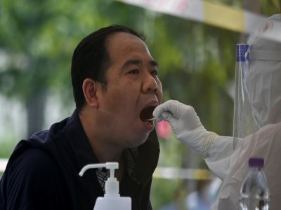 Un Chinois est testÃ© au coronavirus, le 18 juin 2020 Ã  PÃ©kin - STR [AFP]